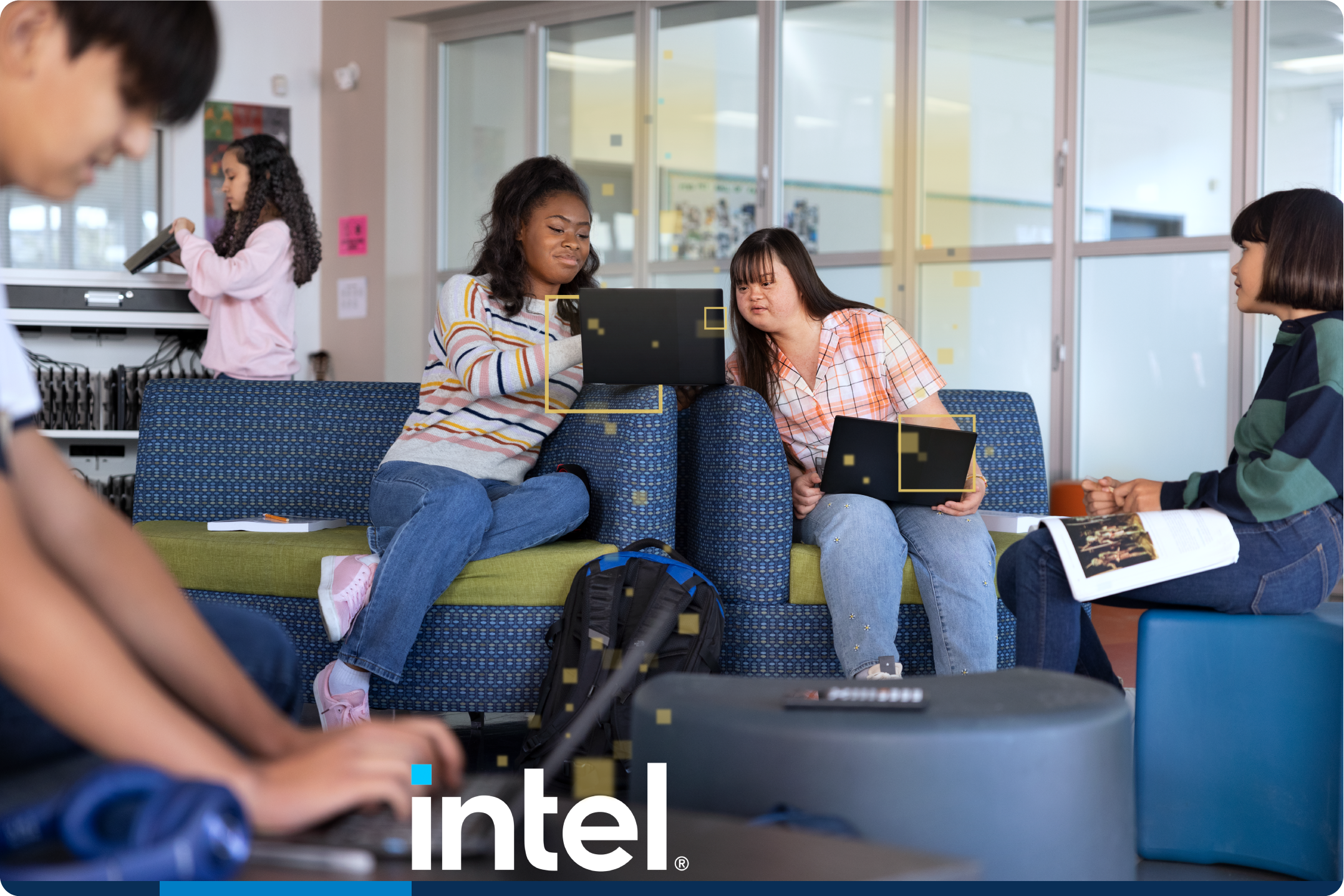 Two girls work with their laptops in the classroom