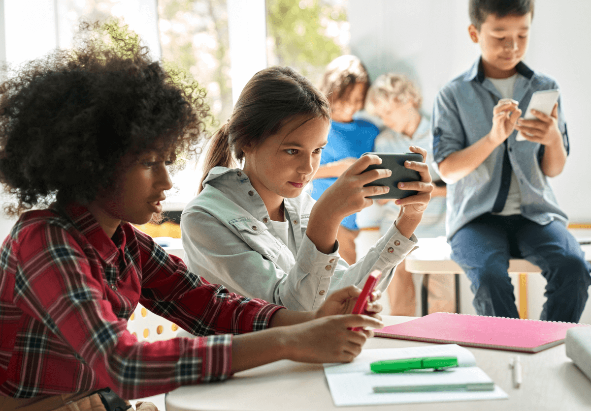 Niños con móviles en un aula