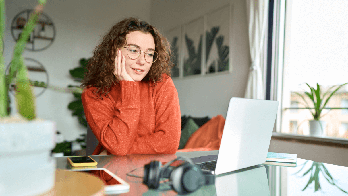 Young woman student using laptop looking at computer