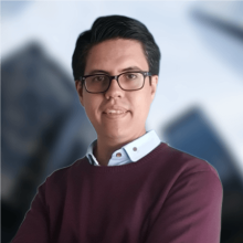 Man in a suit with glasses, from chest up looking forward